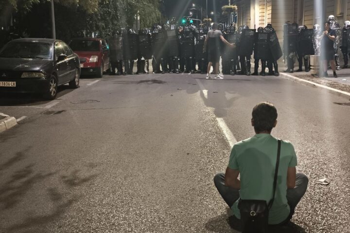 demonstrant pred kordonom policije